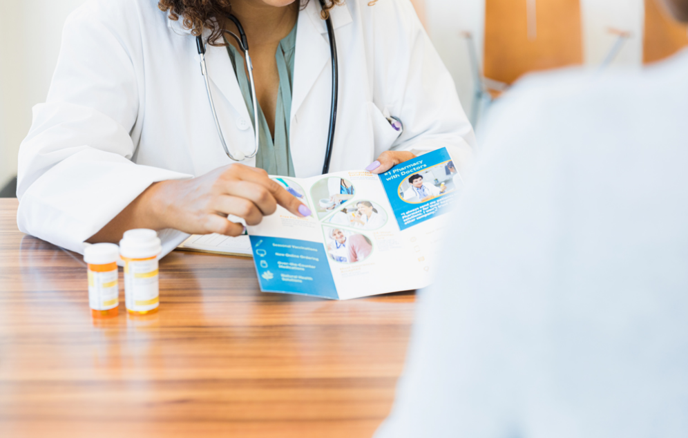 Image of a health care professional explaining promotional material with a patient.